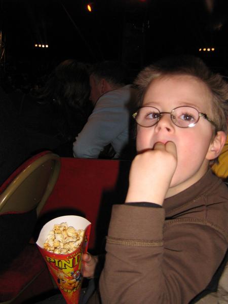 il attend le spectacle du cirque,et bien sûre il a droit à des pop'corns et moi!!!... rien